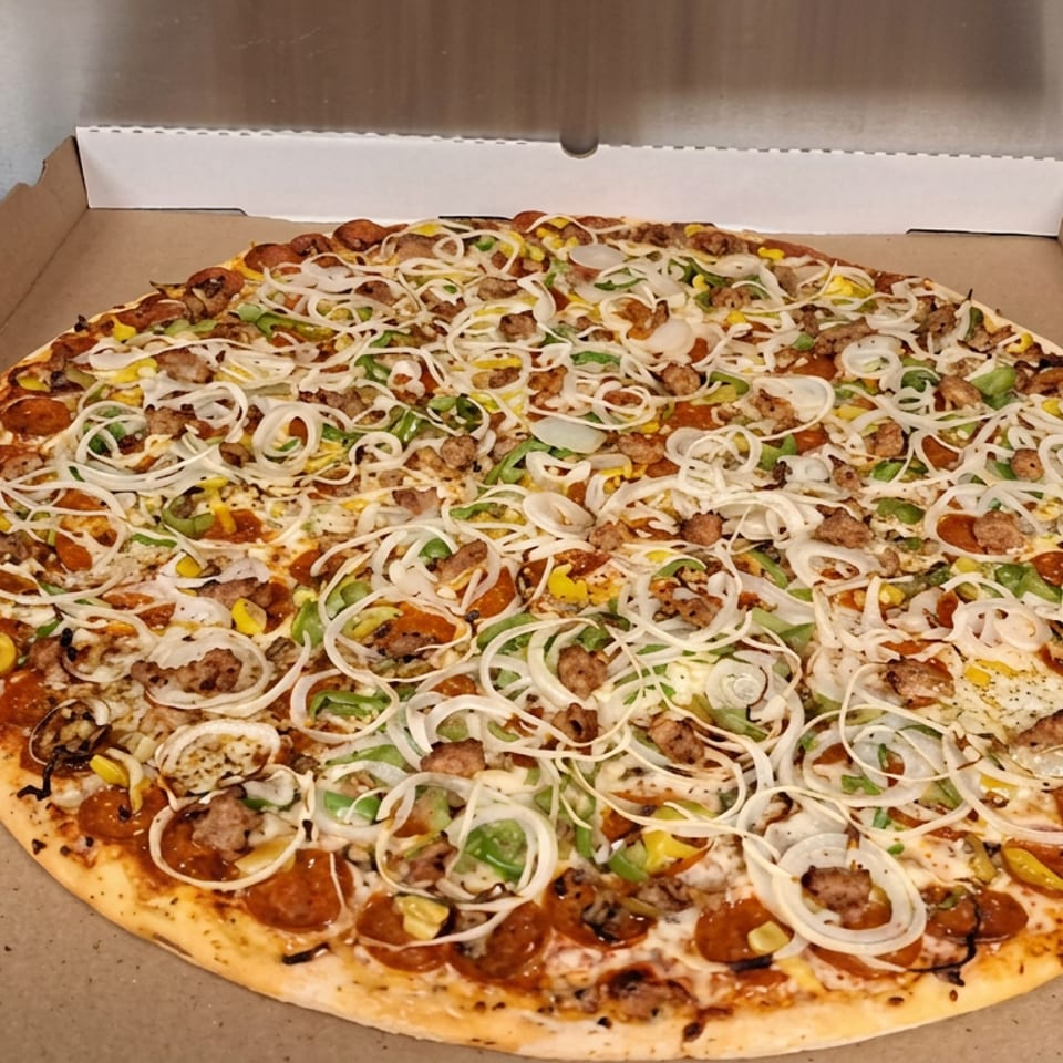 Large loaded pizza topped with sausage, onions, mushrooms, green peppers, and yellow peppers in an open cardboard box.